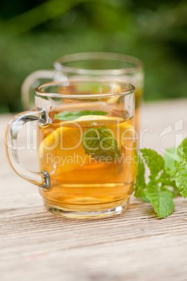 fresh tasty hot tea lemon and mint outdoor in summer