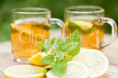 fresh tasty hot tea lemon and mint outdoor in summer