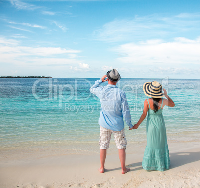 Vacation Couple walking on tropical beach Maldives.