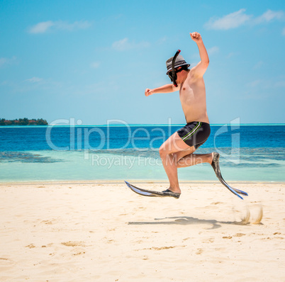 Funny man jumping in flippers and mask.