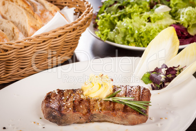 Grilled beef steak topped with butter and rosemary