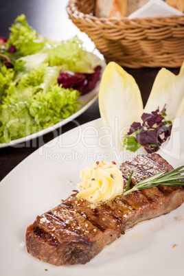 Grilled beef steak topped with butter and rosemary