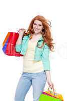 smiling young redhead girl with colorful shoppingbags