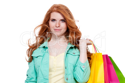 smiling young redhead girl with colorful shoppingbags