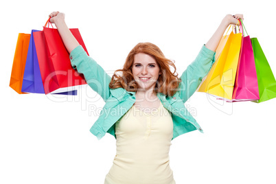 smiling young redhead girl with colorful shoppingbags