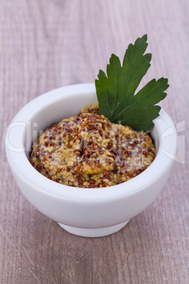 fresh yellow mustard in white bowl with parsley decorated