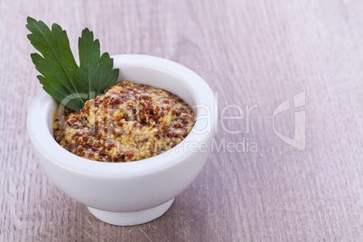 fresh yellow mustard in white bowl with parsley decorated