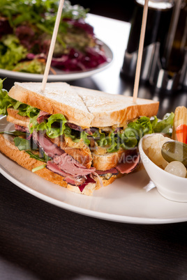 Delicious pastrami club sandwich and pickles