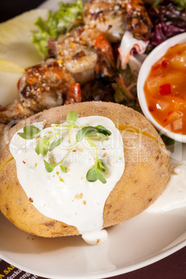 Grilled prawns with endive salad and jacket potato