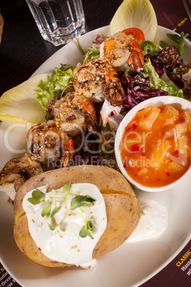 Grilled prawns with endive salad and jacket potato