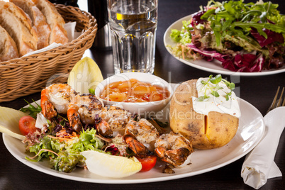 Grilled prawns with endive salad and jacket potato