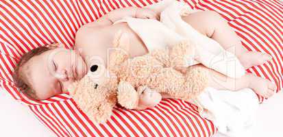 sleeping cute little baby on red and white stripes pillow