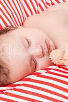 sleeping cute little baby on red and white stripes pillow