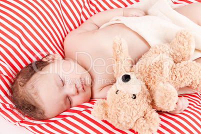 sleeping cute little baby on red and white stripes pillow