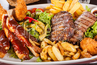 Platter of mixed meats, salad and French fries