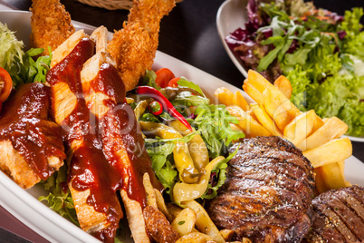 Platter of mixed meats, salad and French fries