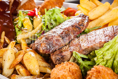 Platter of mixed meats, salad and French fries