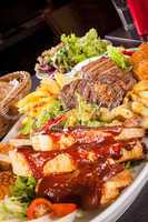 Platter of mixed meats, salad and French fries