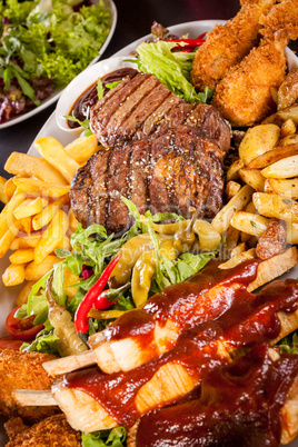 Platter of mixed meats, salad and French fries