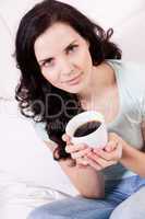 smiling brunette woman drinking black coffee