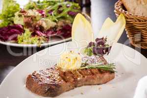 Grilled beef steak topped with butter and rosemary