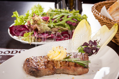 Grilled beef steak topped with butter and rosemary