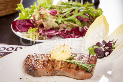 Grilled beef steak topped with butter and rosemary