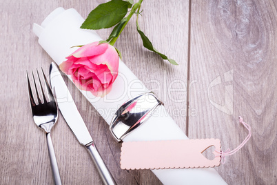 Table setting with a single pink rose