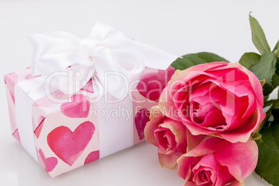 Gift box with an empty tag, next to three roses