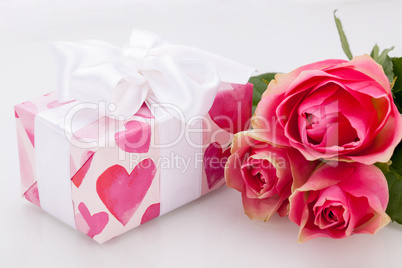 Gift box with an empty tag, next to three roses