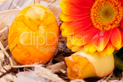 Vivid orange Easter egg with a gerbera and rose
