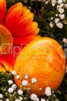 Vivid orange Easter egg with a gerbera and rose