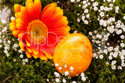 Vivid orange Easter egg with a gerbera and rose