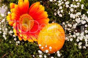 Vivid orange Easter egg with a gerbera and rose