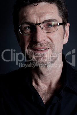 attractive adult man with glasses on black background