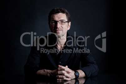 attractive adult man with glasses on black background