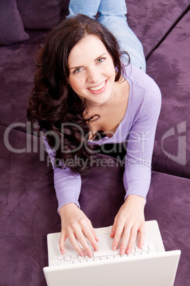 smiling woman on couch with notebook