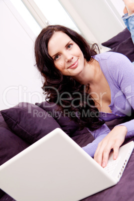 smiling woman on couch with notebook