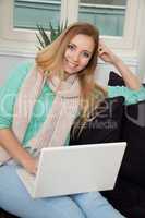 smiling woman on couch with notebook