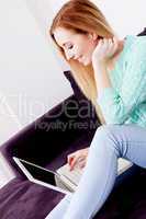 smiling woman on couch with notebook