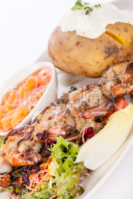 Grilled prawns with endive salad and jacket potato