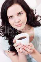 smiling brunette woman drinking black coffee