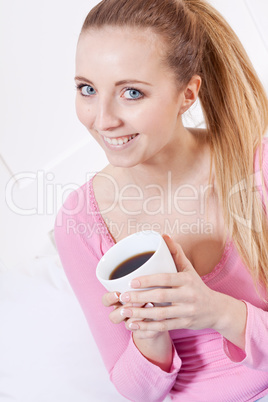 smiling young blonde woman drinking coffee