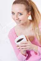 smiling young blonde woman drinking coffee