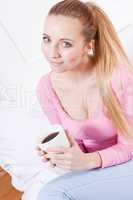 smiling young blonde woman drinking coffee