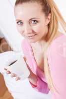 smiling young blonde woman drinking coffee