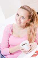 smiling young blonde woman drinking coffee