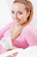 smiling young blonde woman drinking coffee