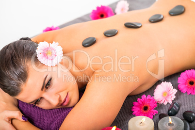 young attractive woman hot stone massage wellness