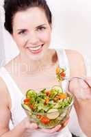 smiling woman eating fresh salad
